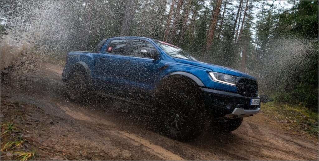 blue ford ranger raptor driving in forest