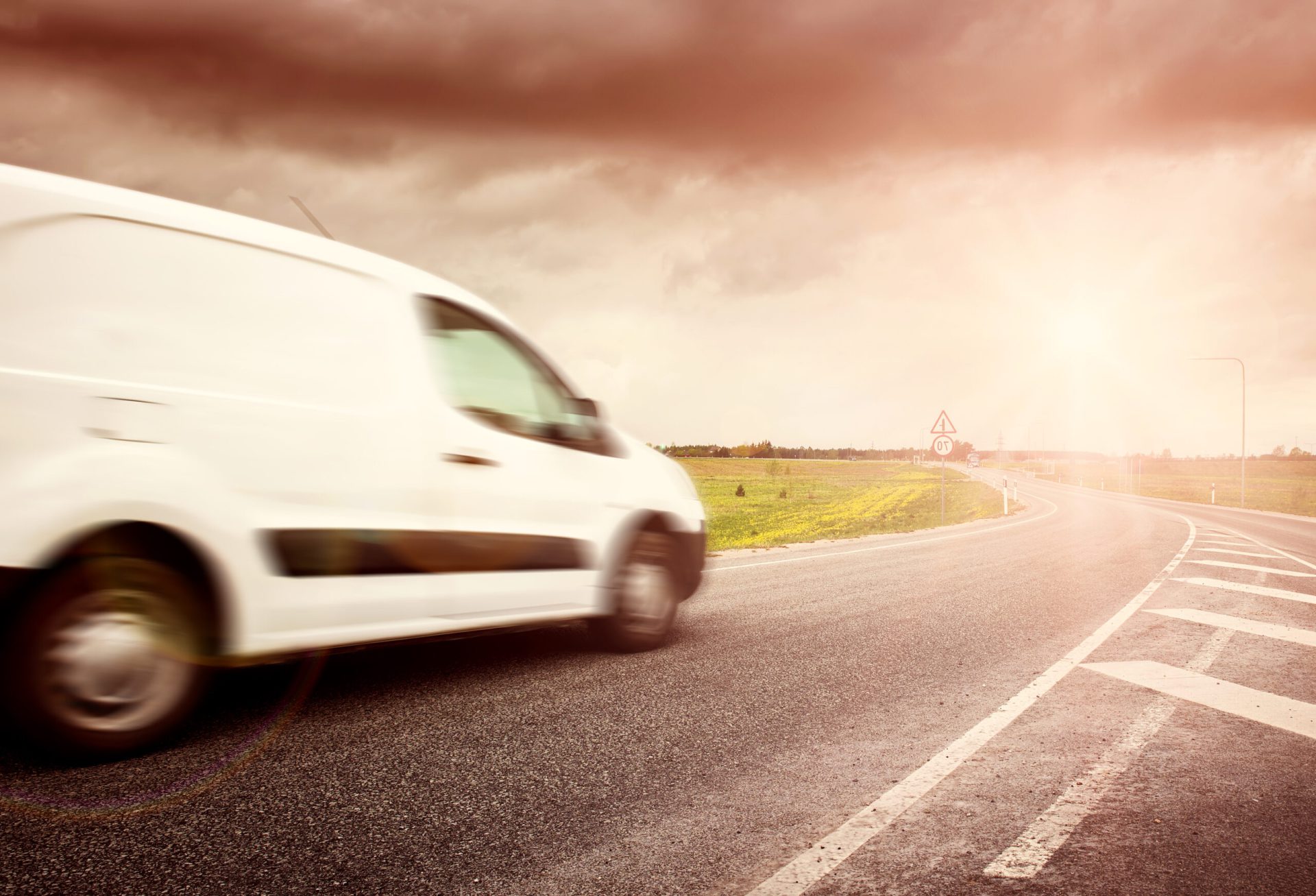 small van driving on a road